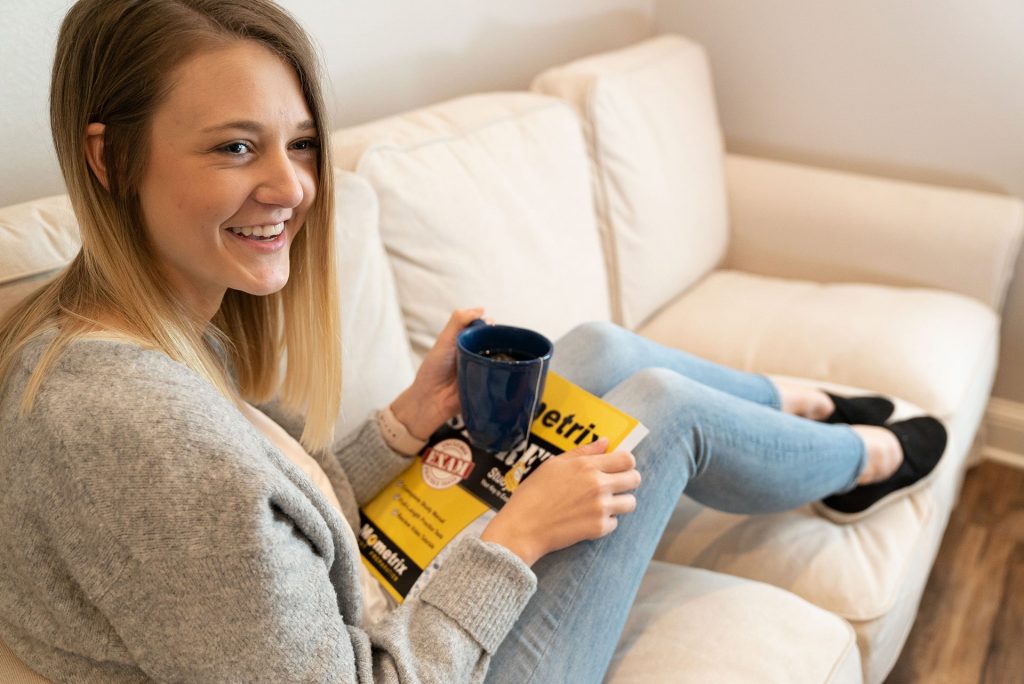 A female student with a cup of coffee and a Mometrix Test Preparation study guide